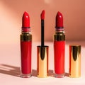 Red lipstick and liquid lip gloss in elegant gold packaging Royalty Free Stock Photo