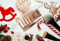 Red lipstick and makeup brushes with christmas decorations on wooden background Royalty Free Stock Photo