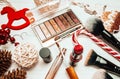 Red lipstick and makeup brushes with christmas decorations on wooden background Royalty Free Stock Photo