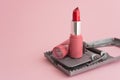 Red lipstick in rat trap on pink background copy space. Online internet romance scam or swindler in website application dating