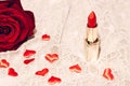 Red lipstick with small hearts and a rose on tender lace fabric
