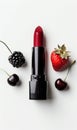 A red lipstick with strawberry and a cherry on a light background Royalty Free Stock Photo