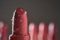 Red lipsticks with water drops on a dark background. Royalty Free Stock Photo