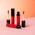 Red liquid lipsticks with applicators, tubes on a pink surface Royalty Free Stock Photo