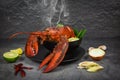 Red lobster spicy soup bowl - Cooked seafood with lobster dinner table and spices ingredients on black plate thai food