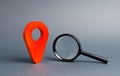 Red location pointer and a Magnifying glass on a gray background. Concept of navigation and venue. Tourism and travel. Spying