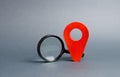 Red location pointer and a Magnifying glass on a gray background. Tourism and travel. Spying on the citizens.. Orientation around