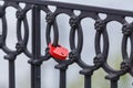 Red lock hanging on forged fence