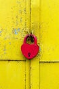 Red lock on a rusty yellow door Royalty Free Stock Photo