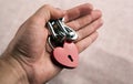 Red locked heart shaped padlock with steel chain in the male palm