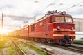 Red locomotive electric with a freight train at high speed rides by rail. Royalty Free Stock Photo