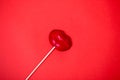 Red lollipop on coral background