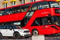 Red London Bus With Passenger And A White Mini Car Travelling On A Road Royalty Free Stock Photo