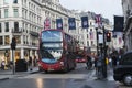 Red London buses during the rush hour in central London taking passengers to and from work and shopping crossing a box junction Royalty Free Stock Photo