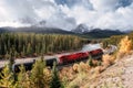 Red long freight train on railway passing through autumn valley with mountain at Morant\'s Curve Royalty Free Stock Photo