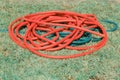 Red long hose on green grass Royalty Free Stock Photo