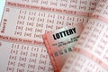 Red lottery ticket lies on pink gambling sheets with numbers for marking to play lottery Royalty Free Stock Photo