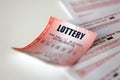 Red lottery ticket lies on pink gambling sheets with numbers for marking to play lottery. Lottery playing concept or gambling Royalty Free Stock Photo
