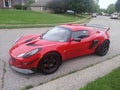 Red Lotus elise parked in suburban neighborhood