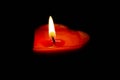 A red love candle displayed on a black background