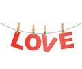 Red love letters hanging on rope with clothespins, isolated on white