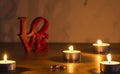 Red love letters on white background on the left wiht two rings and candles Royalty Free Stock Photo