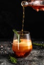 Red low alcohol drink, chilled colorful beverages on rustic black background. summer party. Alcoholic drink concept. Freeze motion