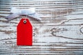 Red luggage tag on vintage wooden board top view