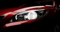 Red luxury car features a brilliantly lit headlight Royalty Free Stock Photo