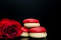 Red macaroon on black background with red roses Royalty Free Stock Photo