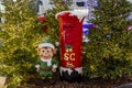 Red mailbox for Christmas mailings with letters to Santa Claus and a toy Elf