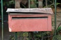 The red mailbox on the iron fence. Royalty Free Stock Photo