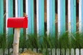 Red mailbox on a multicolored lath background Royalty Free Stock Photo