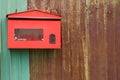 Red mailbox on rusty iron fence