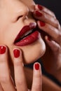 Red, makeup and woman with nail polish and lipstick for cosmetics, hands touching face and cosmetology on black Royalty Free Stock Photo