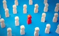 Red man figurine in a people crowd. Stands out from the crowd. Different, special. Collective immunity. Social distance. Intruder