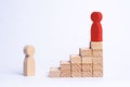 A red man stands at the top of a social or career ladder. Concept of business success. Stairs of people. Use other workers. A wood Royalty Free Stock Photo