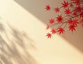 Red maple leaves on beige wall with soft shadows. Branches with bright red foliage cast delicate patterns from sunlight streaming Royalty Free Stock Photo