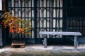 Red maple tree and old wooden bench outside japanese house Royalty Free Stock Photo