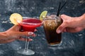 Red margarita cocktail and Rum and Cola Cuba Libre cocktail in a woman& x27;s hand Royalty Free Stock Photo