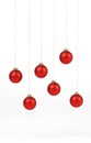 Red matt christmas balls hanging on golden strings on white background