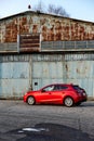 A red Mazda 3 parked in front of an old airplane hangar. Mazda 3, Katowice- Poland, February 15, 2015