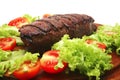 Red meat served on wooden plate with vegetables Royalty Free Stock Photo