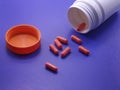 Red medical pills and tablets spilling out of a drug bottle Royalty Free Stock Photo