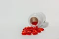 Red medicine pills from a white jar on white background Royalty Free Stock Photo