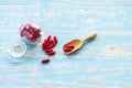 Red medicines in the glass bottles on the wooden spoon and blue table. Royalty Free Stock Photo