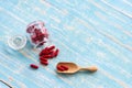 Red medicines in the glass bottles on the wooden spoon and blue table. Royalty Free Stock Photo