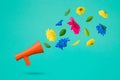 Red megaphone with colorful flowers flying on a turquoise background. Positive news, thinking and energy concept. Optimistic