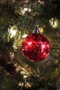 Red mercury glass ball ornament hanging on Christmas tree