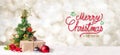 Red Merry Christmas and happy new year handwriting with xmas tree and gift box at blur bokeh light background,Winter holiday Royalty Free Stock Photo
